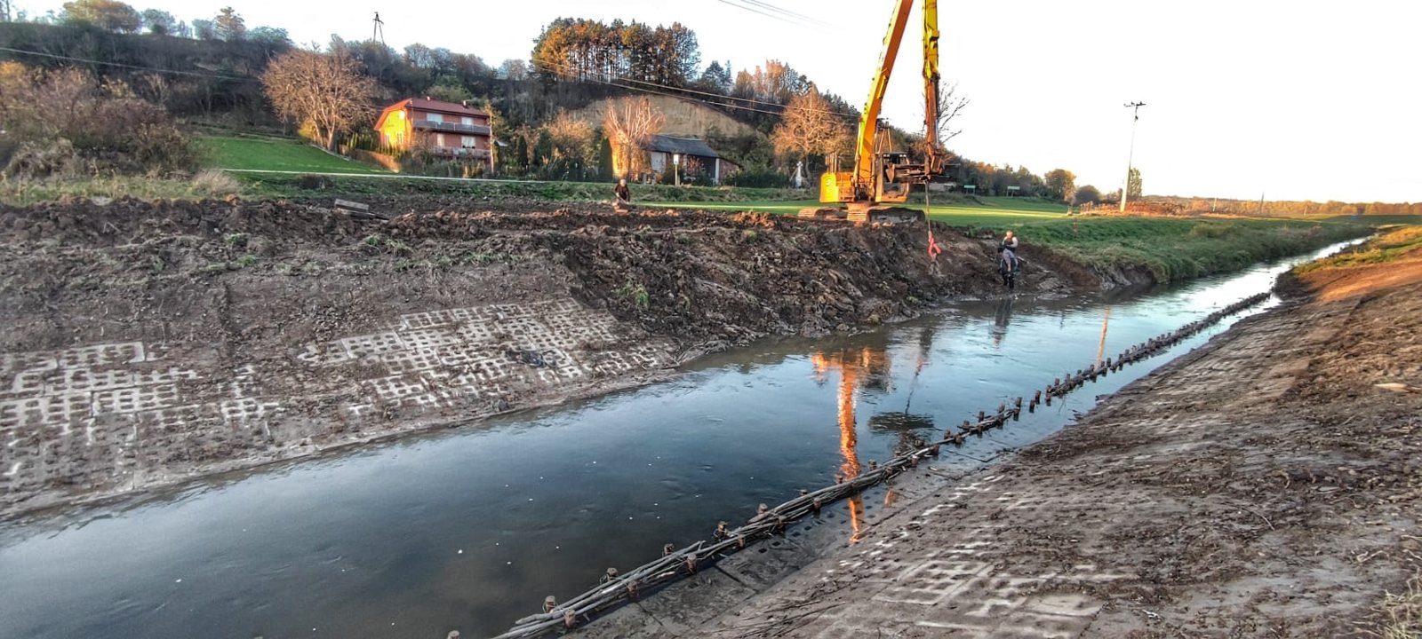 Umocnienie i profilowanie koryta cieku z użyciem koparki w trakcie prac hydrotechnicznych